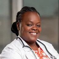 Una doctora sonríe con los brazos cruzados.