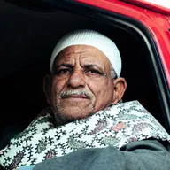 Un hombre mayor mira desde la cabina de su camión.